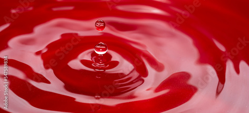 Circles on the water from a falling drop of water. Red abstract background. High quality photo