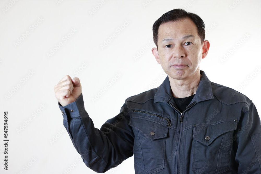 Middle-aged Japanese male worker wearing gray work clothes on white background with hands folded. Concept image of high technology in manufacturing, process work instructions, and working environment. Middle-aged Japanese male worker wearing gray work clothes on white background with hands folded. Concept image of high technology in manufacturing, process work instructions, and working environment.
