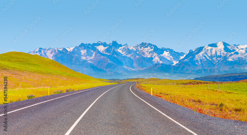 Naklejka premium Empty curve asphalt road to the snowy mountains