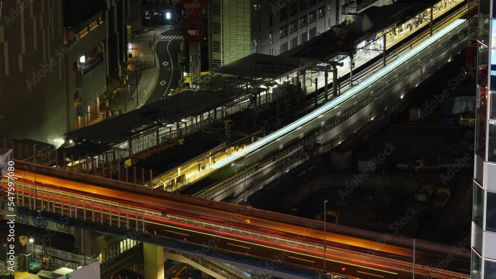 Time lapse view of Shibuya station outdoor platforms, passengers and rail cars pass by. Lively traffic on Route 3 Shibuya line at night time. Long light trails effect from moving vehicles Time lapse view of Shibuya station outdoor platforms, passengers and rail cars pass by. Lively traffic on Route 3 Shibuya line at night time. Long light trails effect from moving vehicles