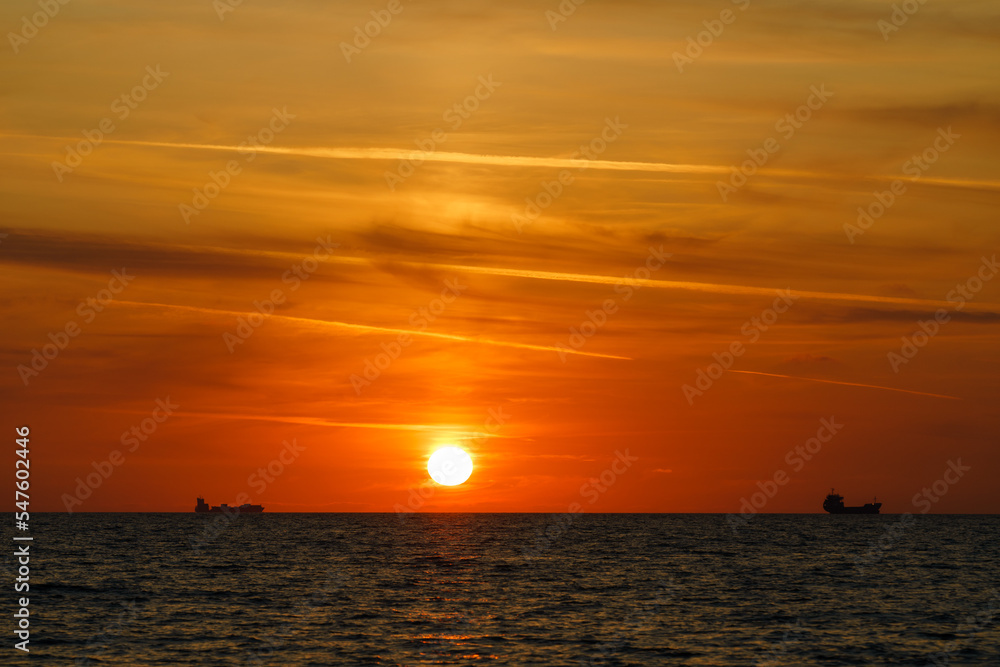 Ships on the horizon at sunset