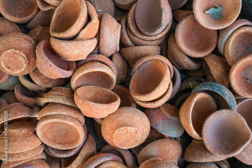 closeup shot of dia or diya made of mud or clay, lit lamp of clay or mud kept in a tub in market to sell, diwali, deepawali , festival of india, deepak, oil lanterns photo