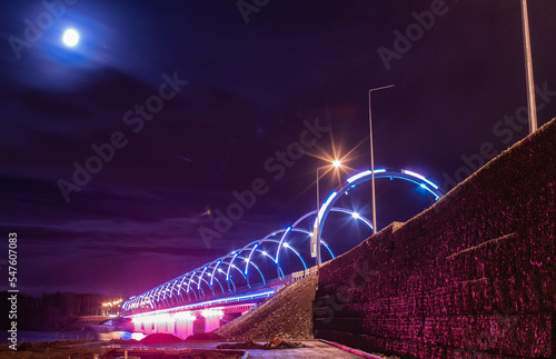 Evening bridge with illumination of different colors across the Tagil River in the Urals. November 2022 photo
