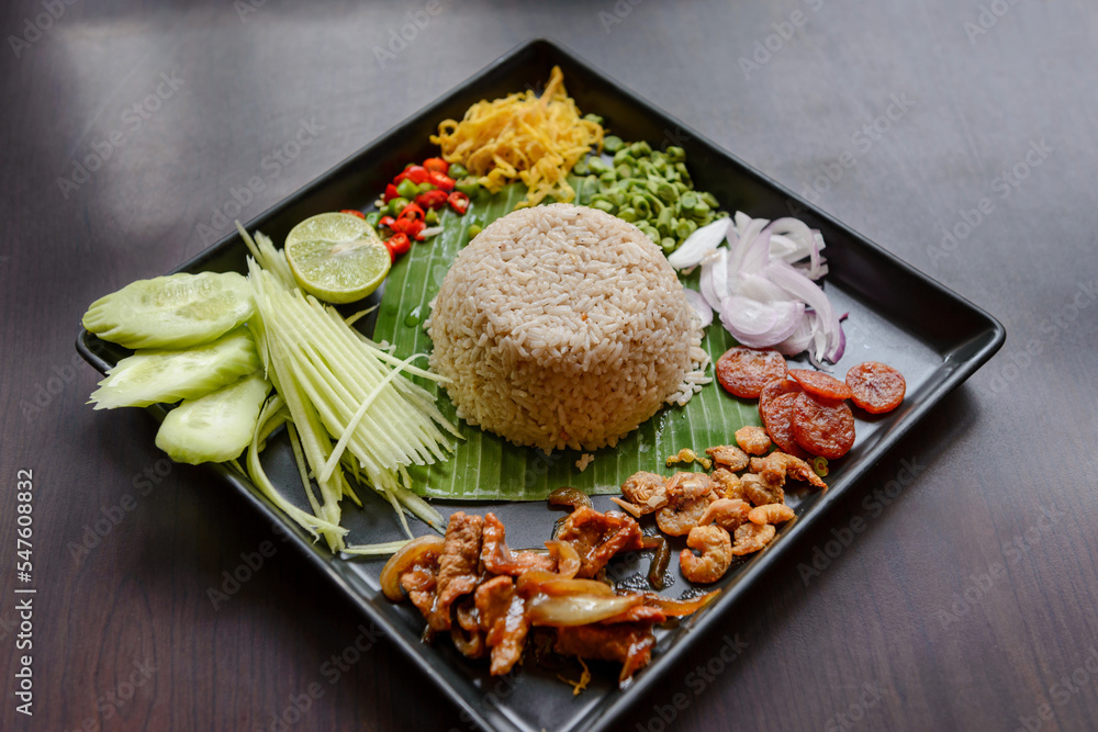 Thai food - Rice mixed with shrimp paste (Kao Cluk Ka Pi) with side dish as a mango, lemon, chili, cucumber, scrambled egg, cow-pea, shallots, Chinese sausage, dried shrimp and pork - obrazy, fototapety, plakaty 