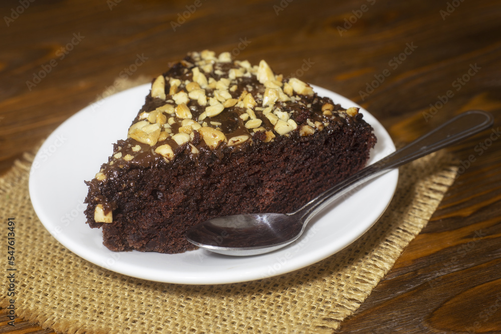 Piece of chocolate cake brownie and a spoon. Calories in a piece of chocolate cake