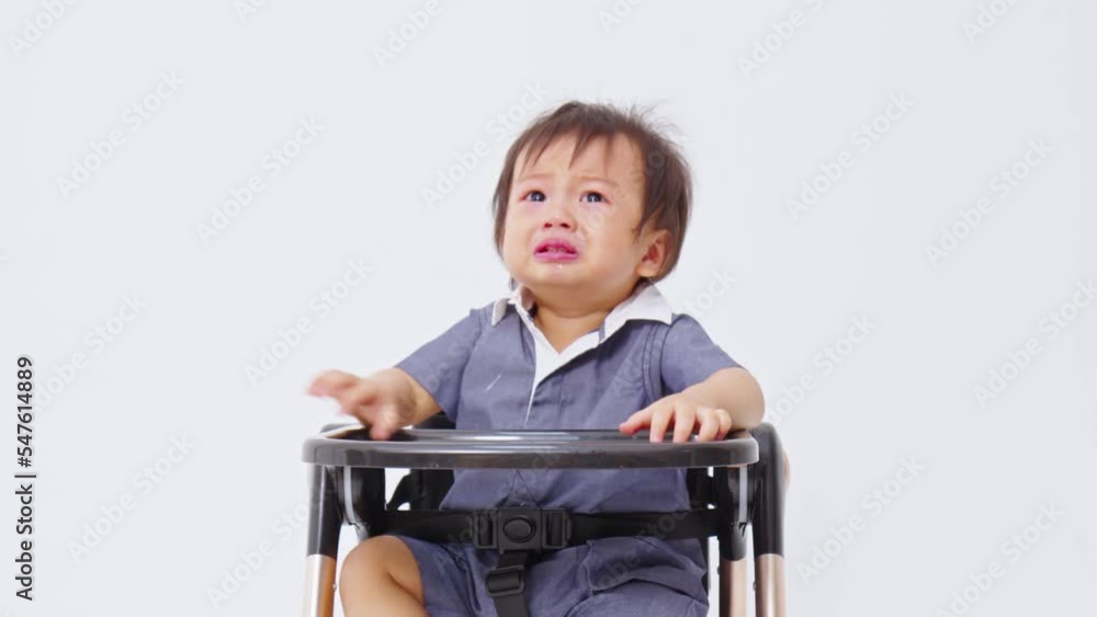 Crying baby boy sitting on chair alone at home. Crisis of develop emotion of baby. Crying baby boy sitting on chair alone at home. Crisis of develop emotion of baby.