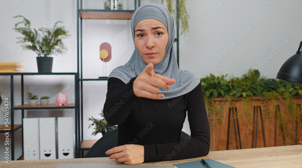 Hey you. Young muslim business woman wearing hijab smiling excitedly ...