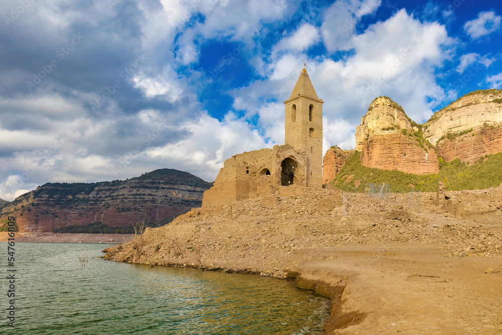 Panoramic view of the Sau reservoir, the church of Sant Roma and the Puig de la Força, autumn drought 2022, reservoir at 18%, Catalonia, Spain