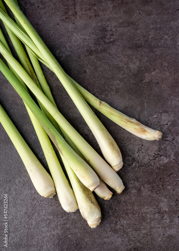 Fresh Lemongrass on dark background. Aromatic herb. Tradicional medicine. For inscent repellent herb. Top view. photo