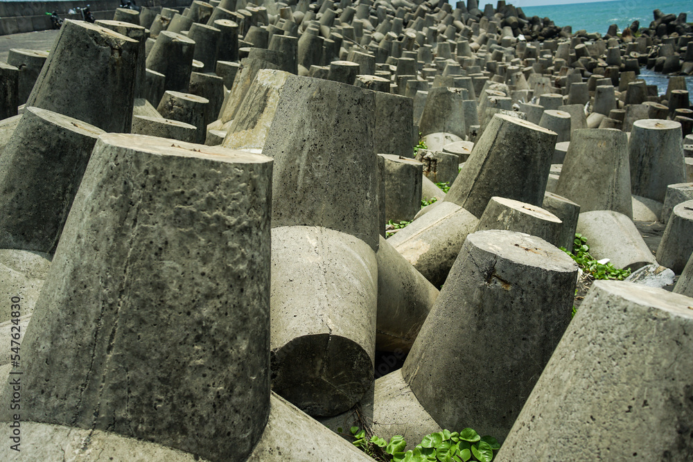 concrete tetrapod breakwaters for strengthening the seashore, lie all along the coast. Concrete tetrapod breakwaters protecting from large waves.