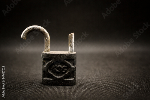 Old rusty broken padlock isolated on black background