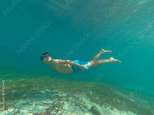 underwater snece of man snorkeling  on the  beach. Concept of holiday relax summer beach diver in the sea	