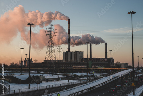 power station at sunset in the big city, with smoke coming out from the chimneys. photo