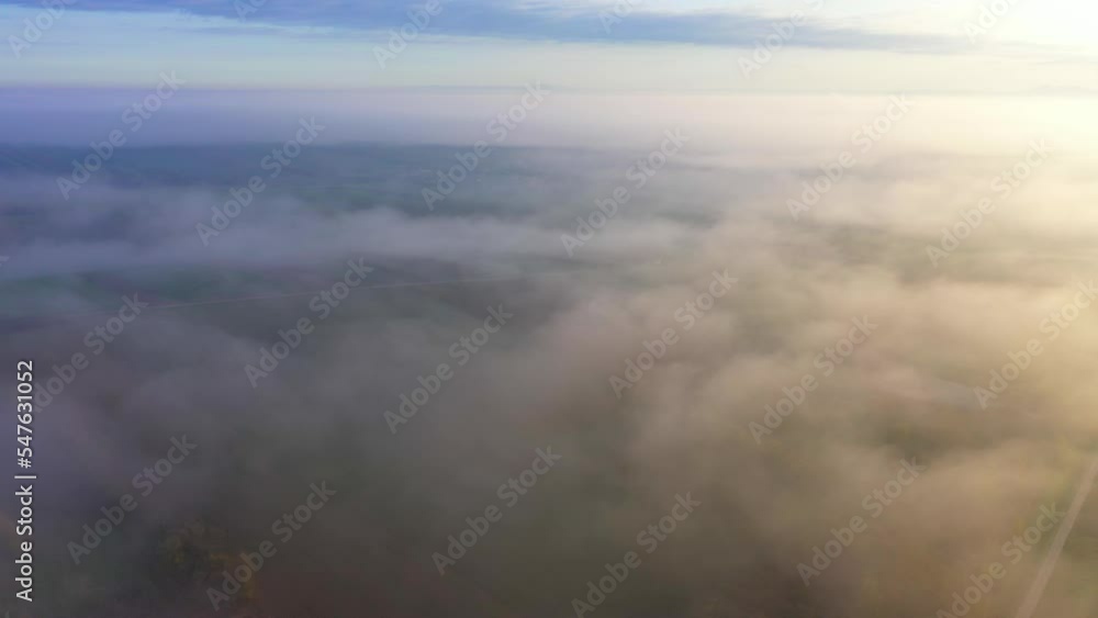 Foggy Clouds Engulfing Countryside Landscape During Autumn In Sunrise. Aerial Drone Shot Foggy Clouds Engulfing Countryside Landscape During Autumn In Sunrise. Aerial Drone Shot