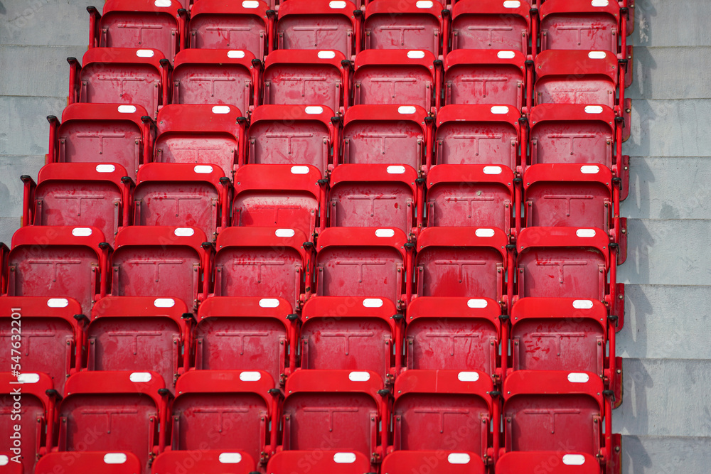 A row of red seating chair in VIP stand area at sport stadium, close-up and selective focus. Sport object background pattern photo. A row of red seating chair in VIP stand area at sport stadium, close-up and selective focus. Sport object background pattern photo.