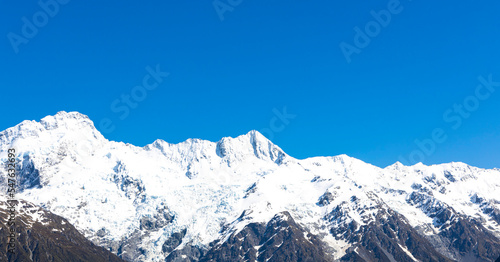 The mountain view of alpine as snow-capped mount peaks in Swiss Mountain alps against the blue sky background