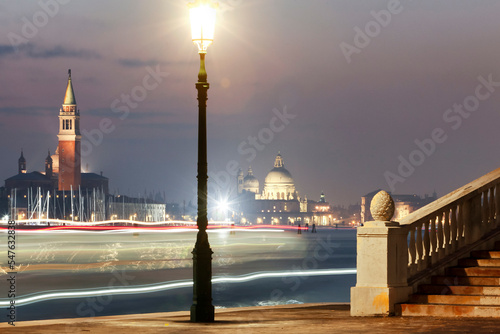 Venezia. Bacino di San Marco con monumenti , lampione e scie luminose di vaporetto  photo