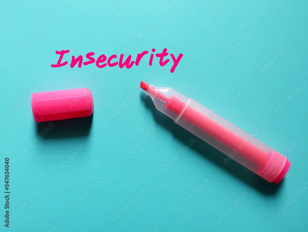 Pink highlight pen write on blue paper INSECURITY, concept of overcome being insecure, or the fear that we are not good enough, and build self-esteem Pink highlight pen write on blue paper INSECURITY, concept of overcome being insecure, or the fear that we are not good enough, and build self-esteem