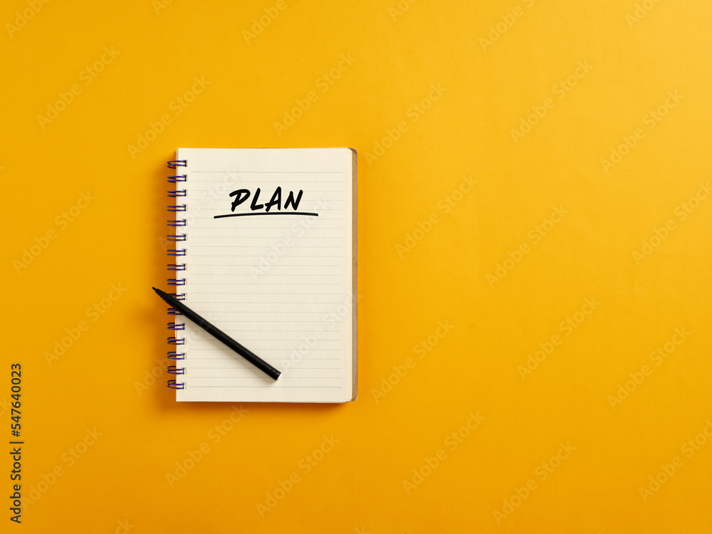 Notepad and black pen with the word plan. Business or financial strategic plan Notepad and black pen with the word plan. Business or financial strategic plan