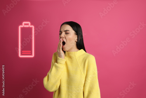 Tired woman yawning and illustration of discharged battery on pink background photo