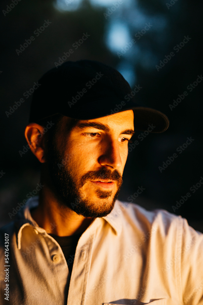 Portrait of a young bearded man, wearing a black cap, at countryside Portrait of a young bearded man, wearing a black cap, at countryside