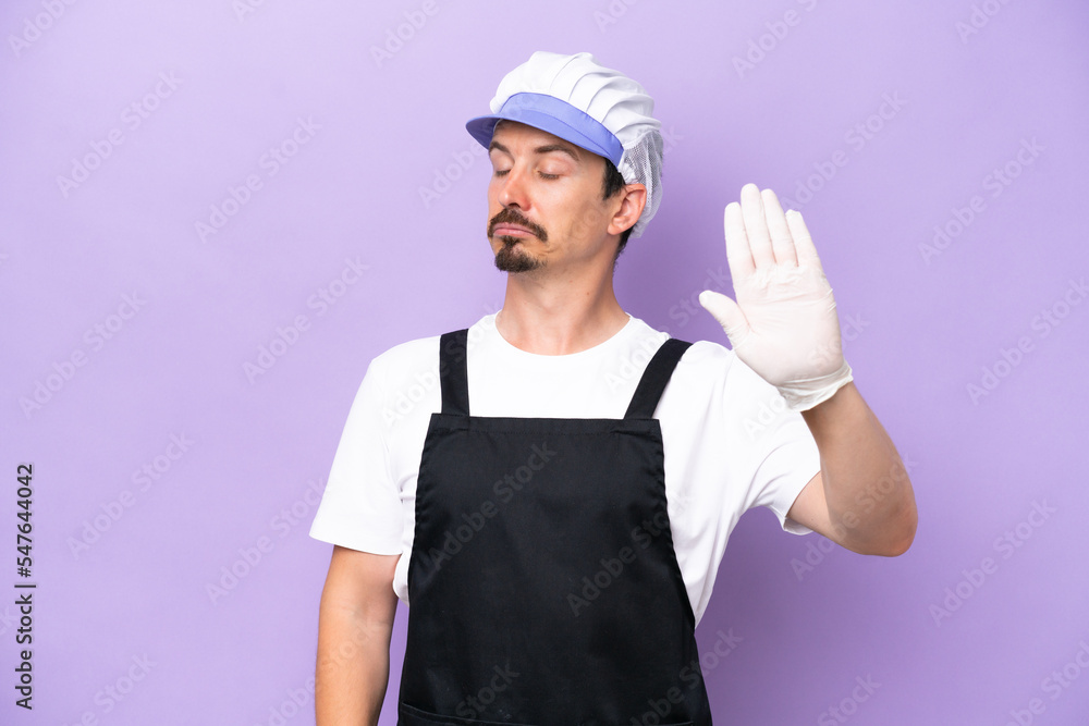 Fishmonger man wearing an apron isolated on purple background making stop gesture and disappointed Fishmonger man wearing an apron isolated on purple background making stop gesture and disappointed
