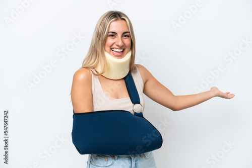Woman with broken arm and wearing a sling isolated on white background extending hands to the side for inviting to come