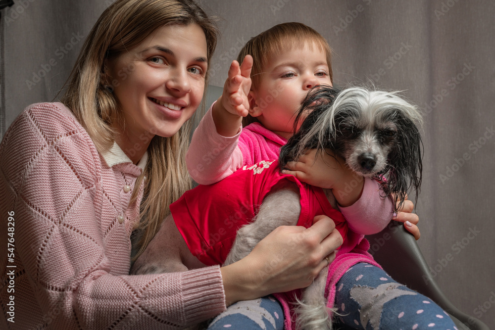 A beautiful young mother with a little daughter is photographed in a home studio. A beautiful young mother with a little daughter is photographed in a home studio.
