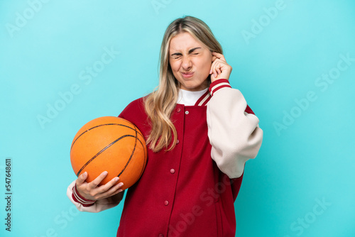 Young caucasian basketball player woman isolated on blue background frustrated and covering ears