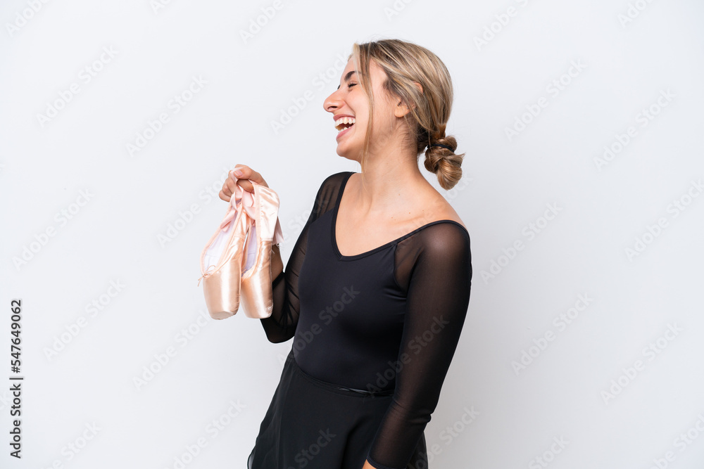 Young caucasian woman practicing ballet isolated on white background laughing in lateral position