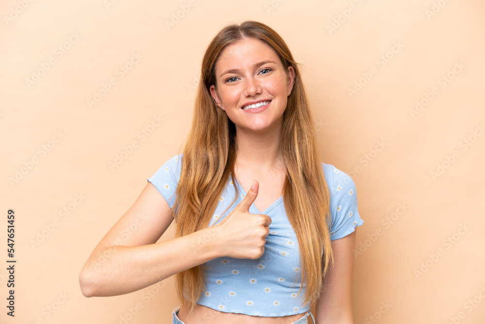 Young caucasian woman isolated on beige background giving a thumbs up gesture Young caucasian woman isolated on beige background giving a thumbs up gesture