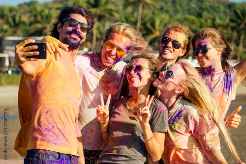 multinational multicultural mixed race friends in holi dust on beach in Goa