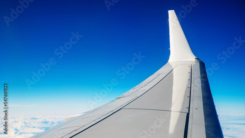 Boeing 737 MAX 8 White Wing Over White Air Clouds And Clear Blue Sky.