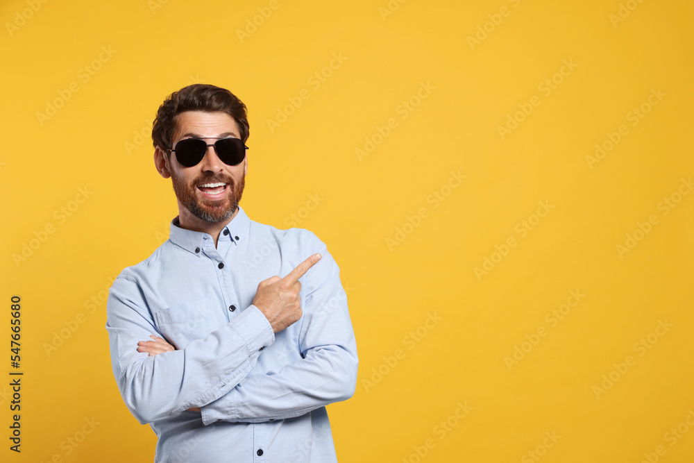 Portrait of excited bearded man with stylish sunglasses on orange background. Space for text Portrait of excited bearded man with stylish sunglasses on orange background. Space for text