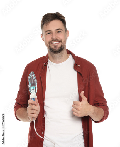 Man holding nebulizer for inhalation and showing thumb up on white background