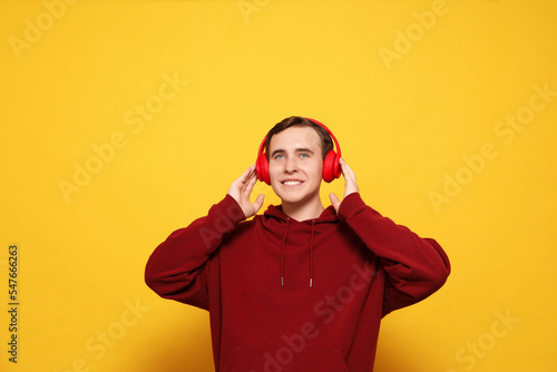 Handsome young man with headphones on yellow background © New Africa