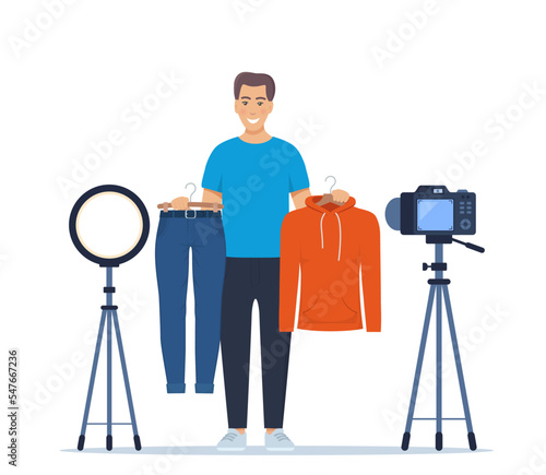 Man blogger records video tips for choosing clothes, shows trending clothing models to his subscribers. Brand or product promotion, marketing campaign in social media. Vector Illustration.