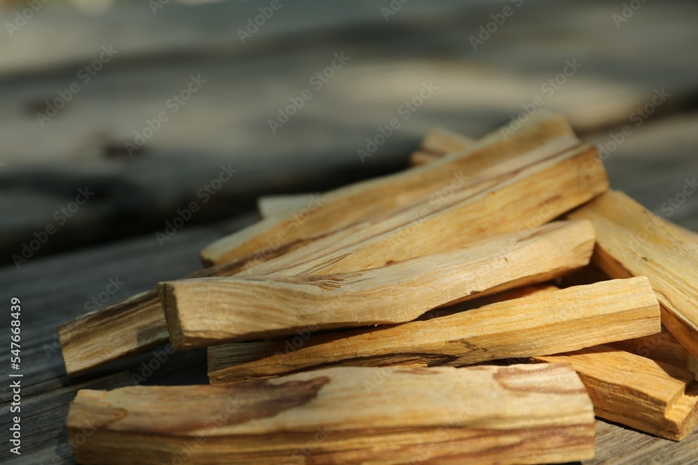 Palo santo sticks on wooden table outdoors