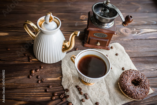 glass of coffee on table with clock in morning. vintage alarm clock showing 9am on the table next to a cup of coffee and a doughnut. Breakfast. Time management concept photo