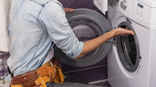 man repairs a washing machine © Angelov