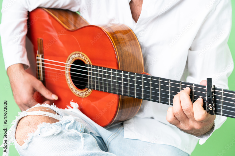 Fototapeta premium Young man with beard with guitar over isolated chroma key background