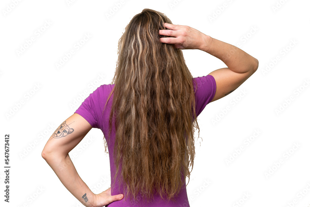 Young blonde woman over isolated background in back position and thinking Young blonde woman over isolated background in back position and thinking