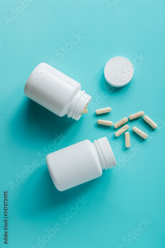 White pill bottles on blue background. Health care food supplements, vitamins and medicaments