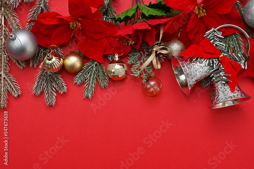 Christmas material  bells and X mas Flower and ball decorations on a red background.