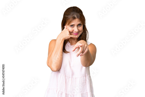 Middle age woman over isolated background making phone gesture and pointing front