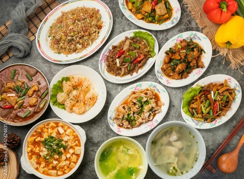 Assorted Shrimp, Sausage and Egg Fried Rice, Mabo tofu, Pineapple Shrimp Balls, large intestine bowl, egg drop soup, Kung Pao Beef, Fish Soup and diced chicken isolated table top view of chinese food