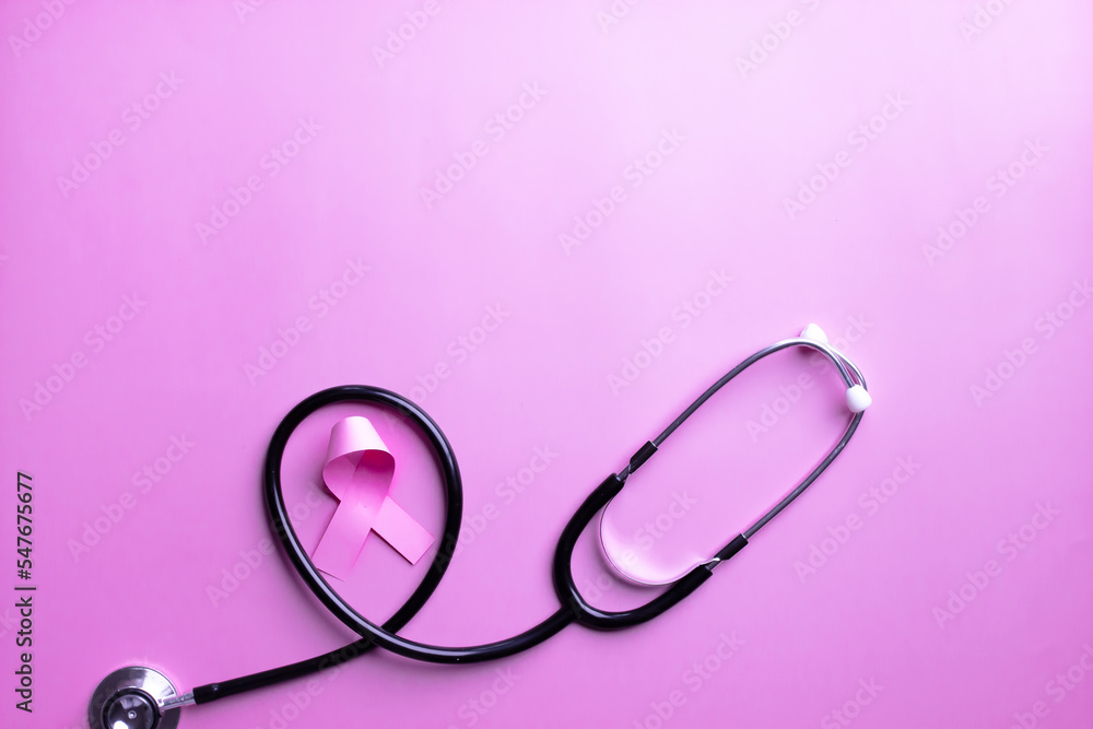 Flat lay of pink ribbon bow with stethoscope on pink background to encourage breast cancer patient. Breast cancer campaign in October month Flat lay of pink ribbon bow with stethoscope on pink background to encourage breast cancer patient. Breast cancer campaign in October month