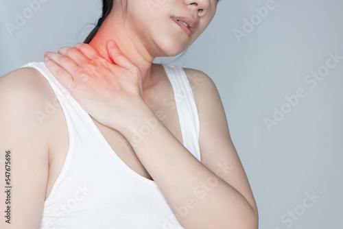 Asian woman touch her nape by hand and feeling stress and pain caused by a bad ergonomic and injure.