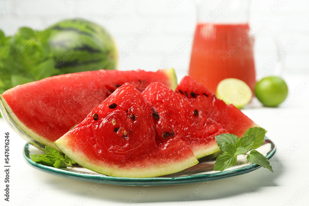 Plate with slices of juicy watermelon on white wooden table Plate with slices of juicy watermelon on white wooden table