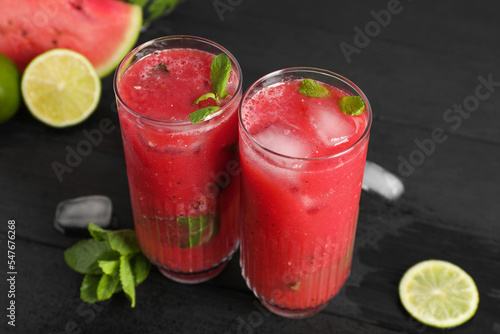 Wallpaper Mural Glasses of delicious fresh watermelon juice, lime, mint and ice on black wooden table Torontodigital.ca